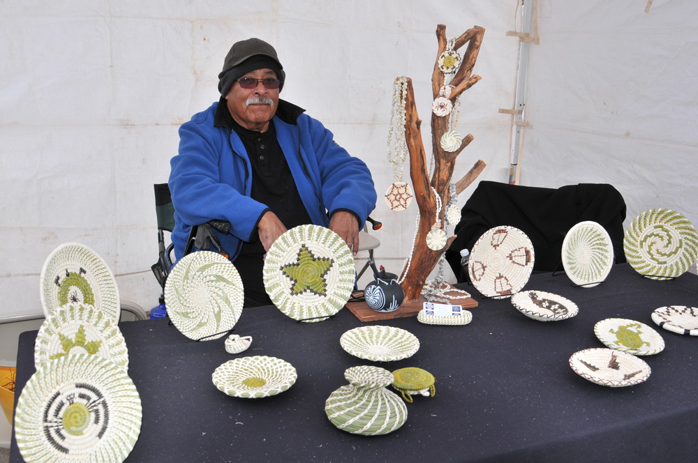 an American Indian basket maker shows off his work in a festival booth