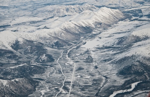 Aerial view of mountains in winter and the Dalton Highway & Trans-Alaska Pipeline