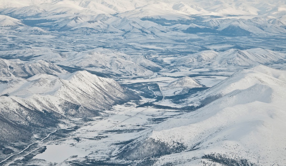 Aerial view of mountains in winter and the Dalton Highway & Trans-Alaska Pipeline