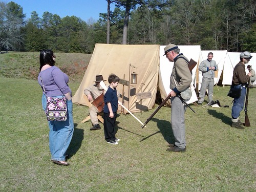 A Confederate Guard teaches a young visitor the finer points of 'Reverse Arms.'