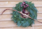 Evergreen wreath with burgundy bow created by Garden Club