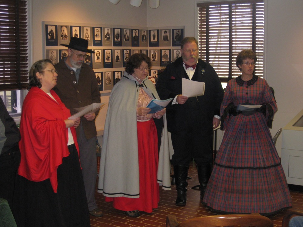 Five Christmas Carolers dressed in 1865 attire.