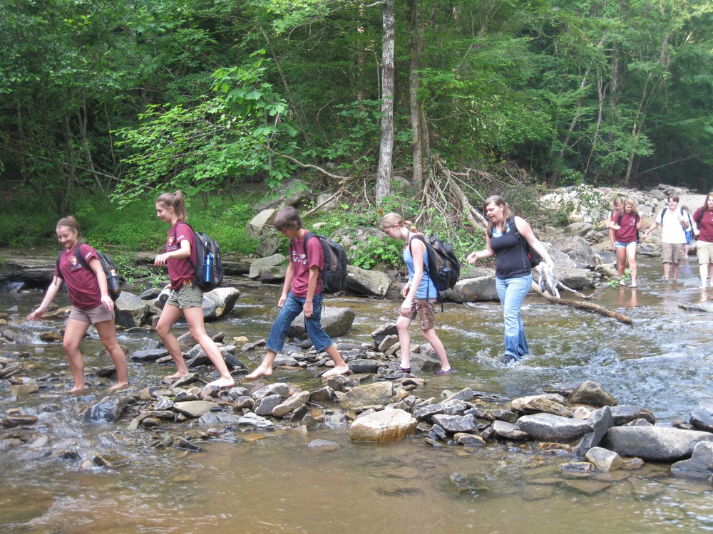 group wading across a creek