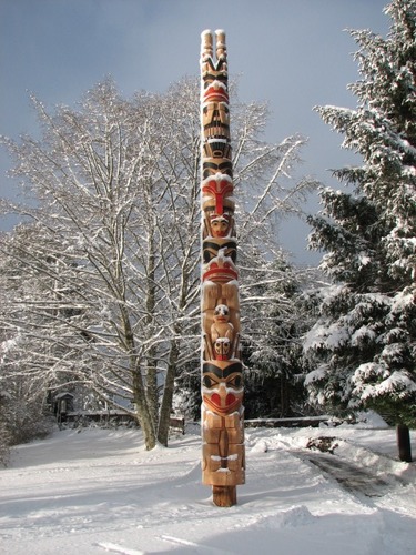 Black and red totem pole in the snow.