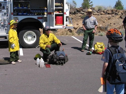 A Junior Firefighter learns about fire equipment during a fun weekend at the Monument.