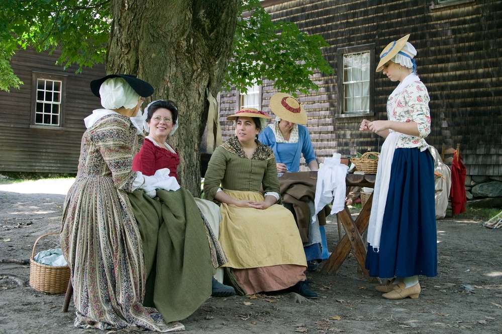 Colonial women at Hartwell Tavern participating in a spinning bee