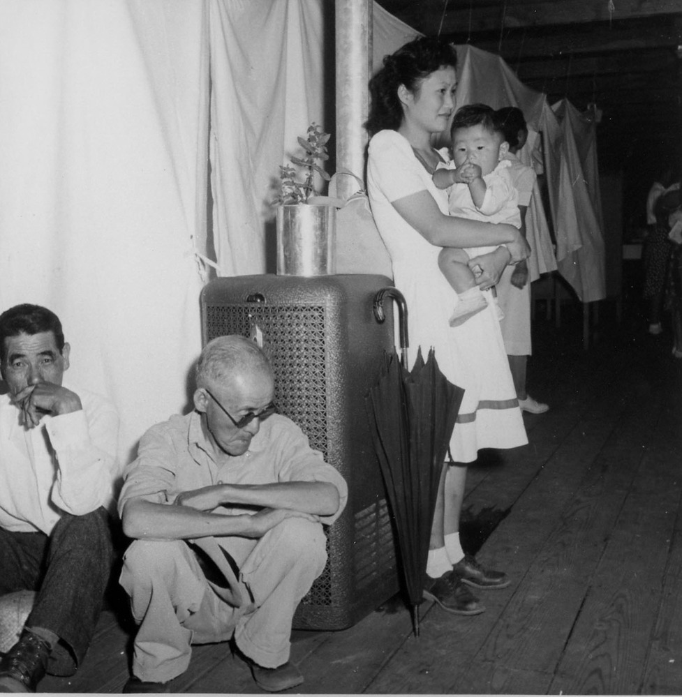 A typical interior scene in one of the barrack apartments at this center. Note the cloth partition which lends a small amount of privacy.