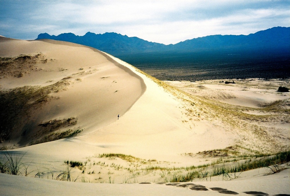 A lone hiker enjoys spectacular scenery and solitude at Kelso Dunes.