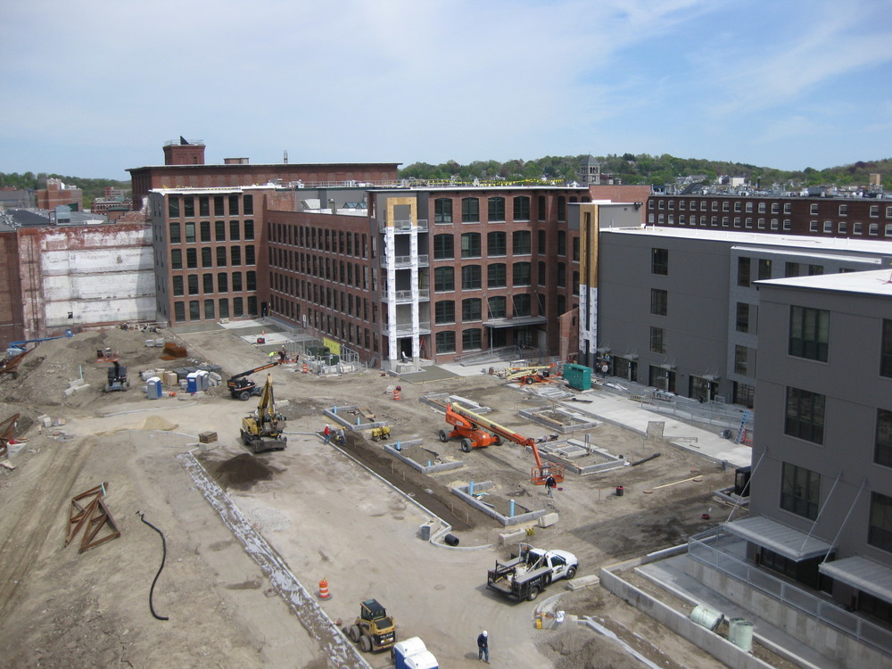 Construction equipment in a vacant lot constructing a new factory building