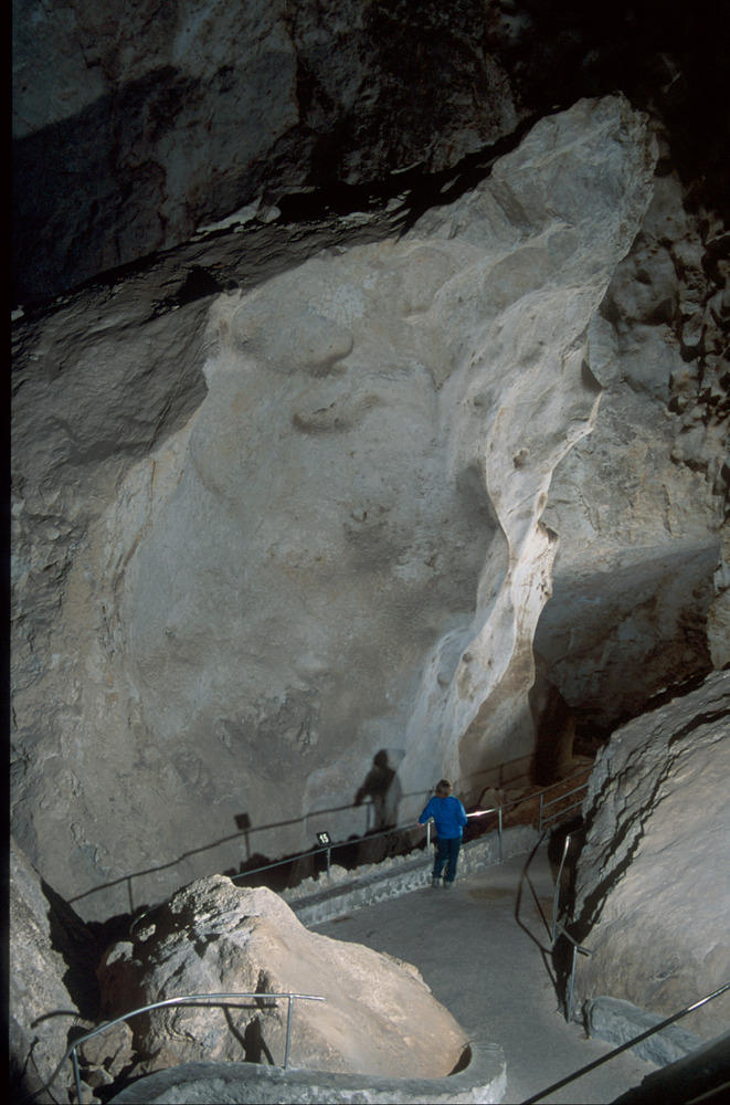 A massive limestone rocks juts out from the cave floor