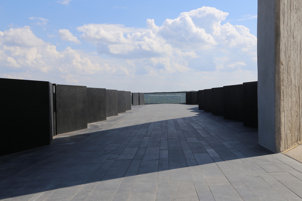 lack walkway with black side walls and a glass panel at the end