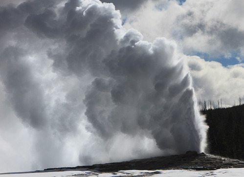 Water shoots straight up in the air and clouds of steam go sideways from the wind.