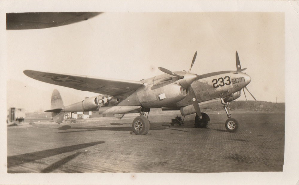 Black and white photo of a prop plane with number 233 on the nose