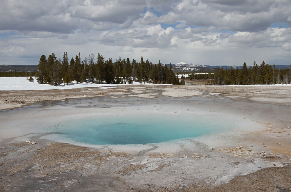 A blue pool of water in an open flat area.
