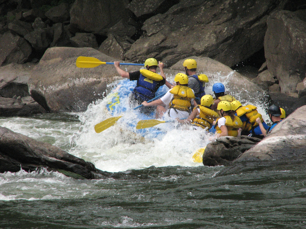 rafters paddle through whitewater