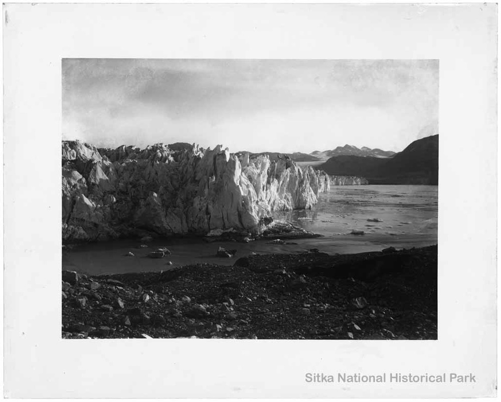 Positive image of a tidewater glacier with mountains in the background.