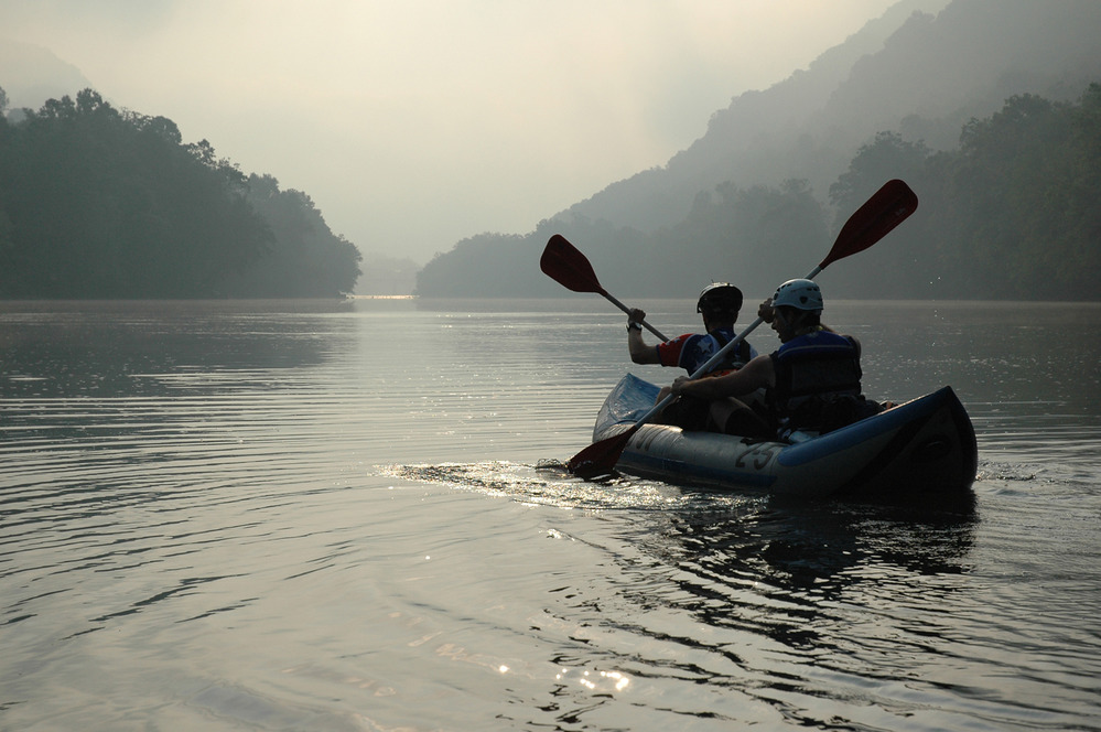 boaters paddle a ducky in calm water