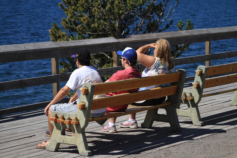 Lake Hotel, visitors sitting on bench looking out at lake