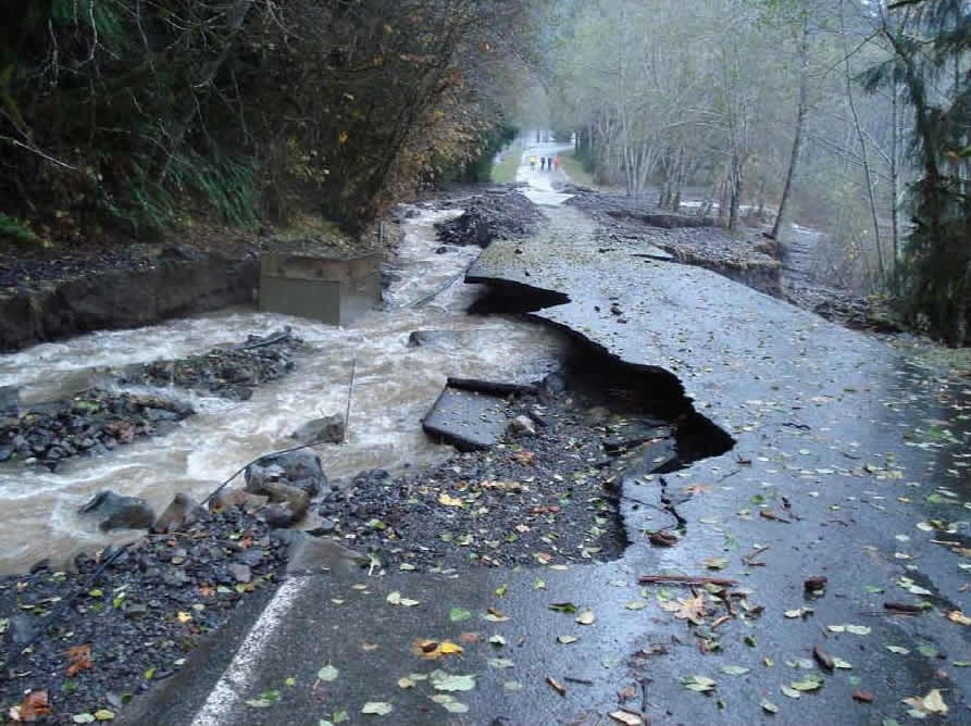 A swollen creek eats away at the Hoh Road near milepost 5.9