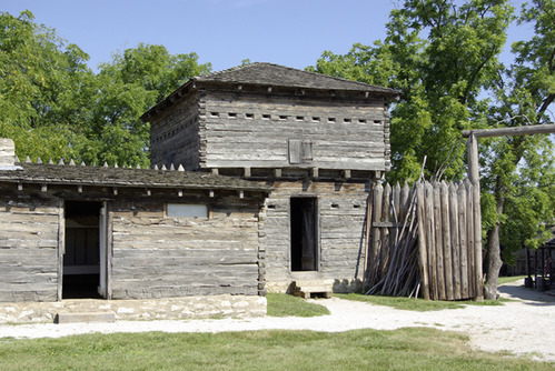 A wooden building wih trees in the background.
