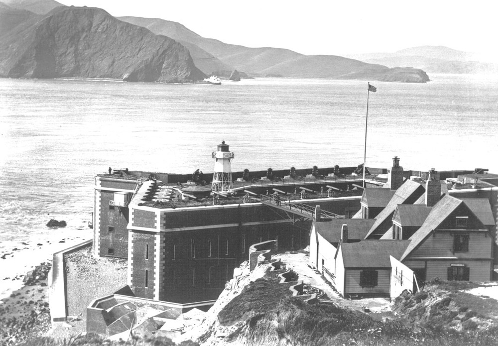 This photo from 1910 shows the Fort Point lighthouse and the metal bridge that connects to the lighthouse keepers' residences, located on top of the bluffs.
