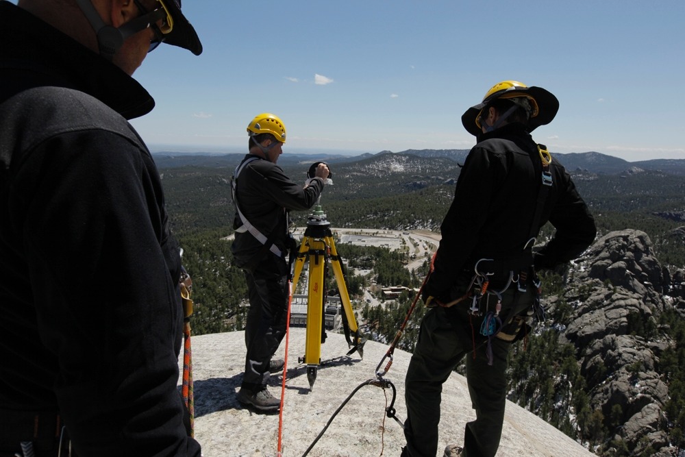 Doug Pritchard of the Glasgow School of Art works with the Mount Rushmore technical ropes team to set a reference target on top of George Washington's head.