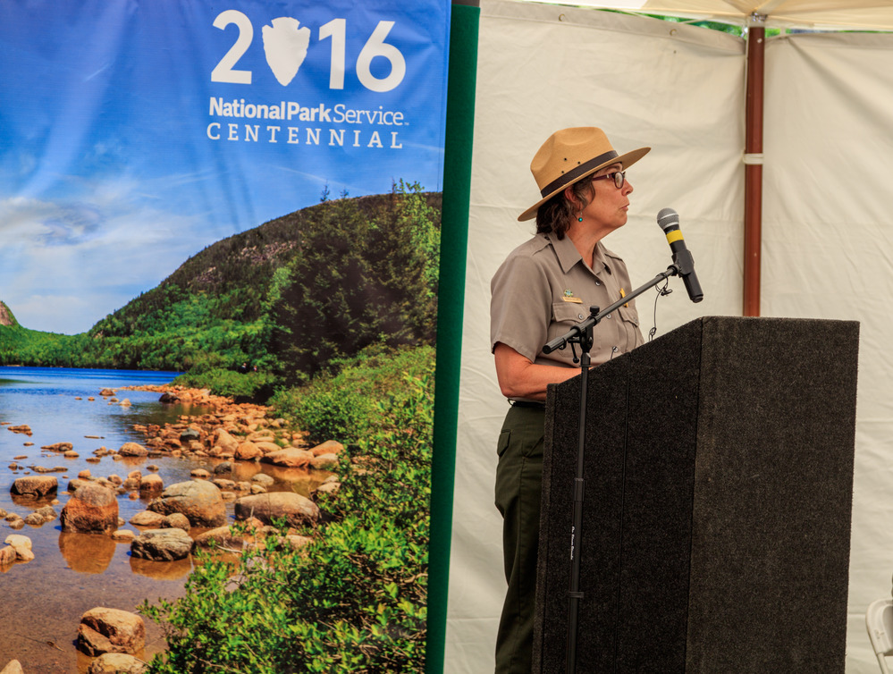 Becky Cole-Will, Chief of Science and Resource Managements, stands at a podium speaking at the opening ceremonies.