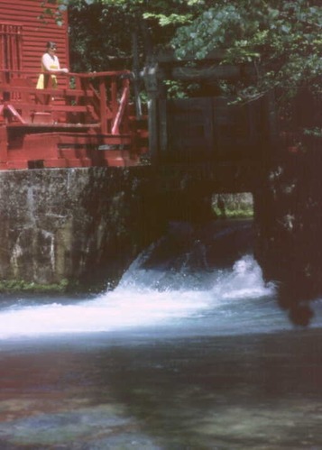 A young woman enjoys the view from the mill's back porch.