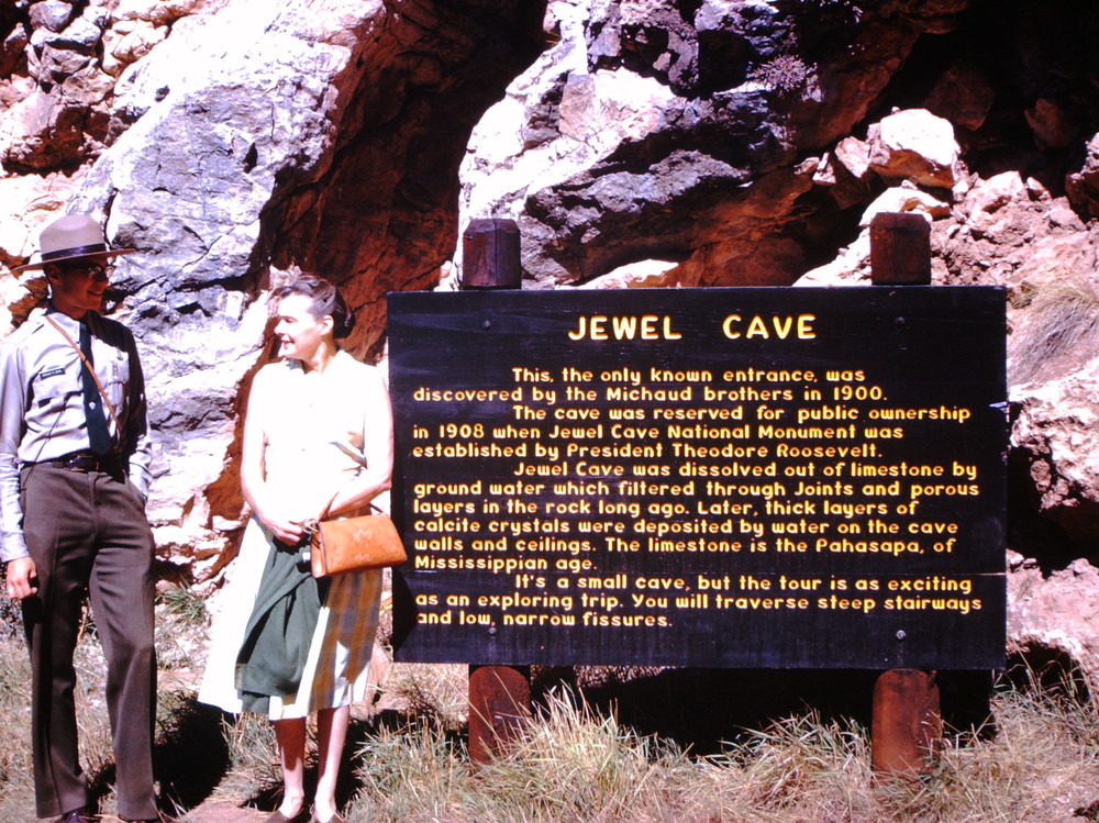 A park ranger and visitor next to an interpretive sign