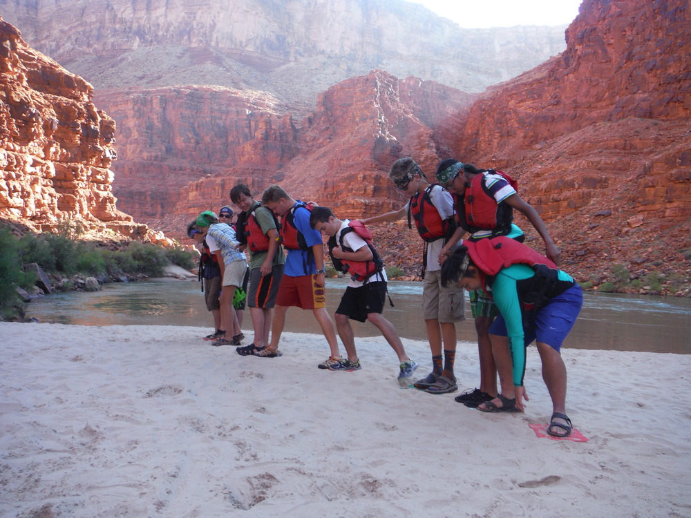 Grand Canyon Unearthed participants doing a team building activity on a beach next to the Colorado River