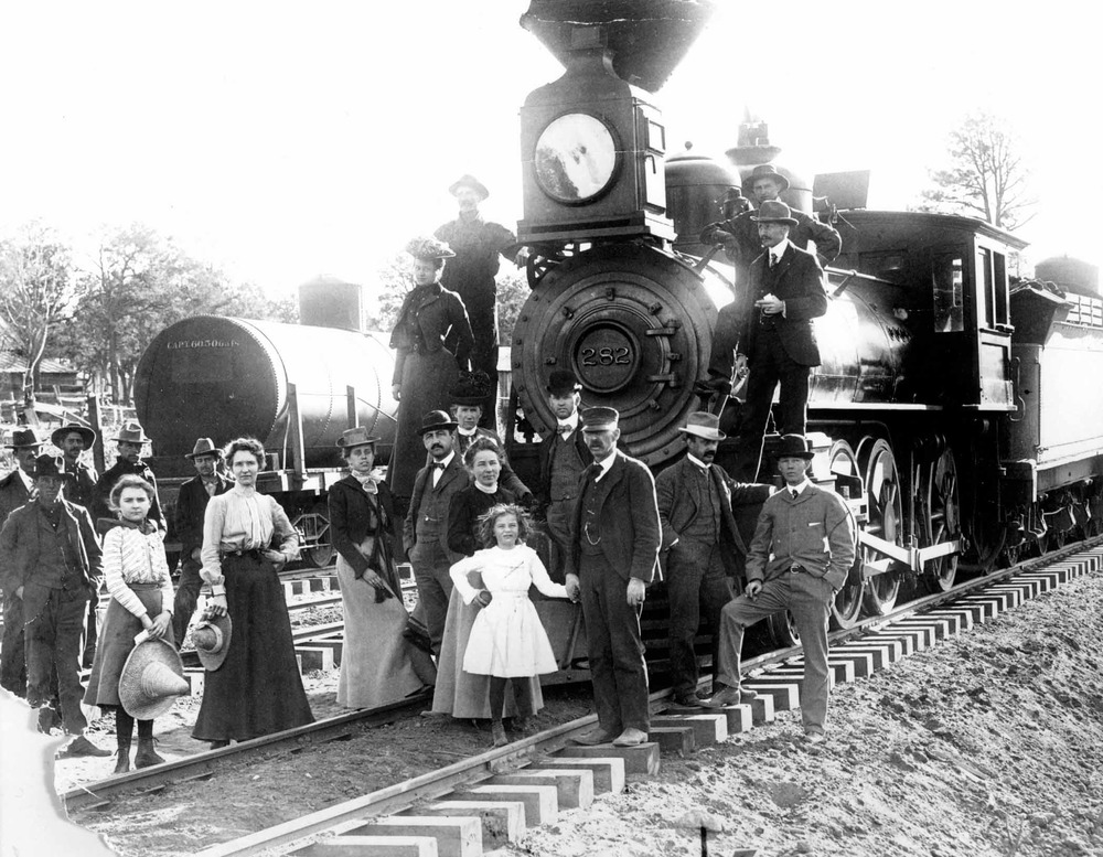 The arrival of the first train to carry passengers all the way to the Grand Canyon Village. The participants pose in front of the locomotive.