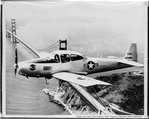 US Army airplane flies over the Golden Gate Bridge on the Fort Baker side.
