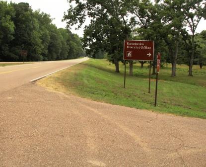 A brown sign with a ranger icon.