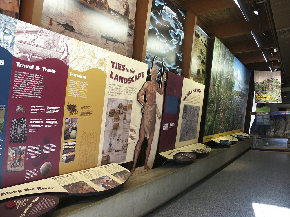 A Native American is depicted holding a bow next to a village of wooden huts