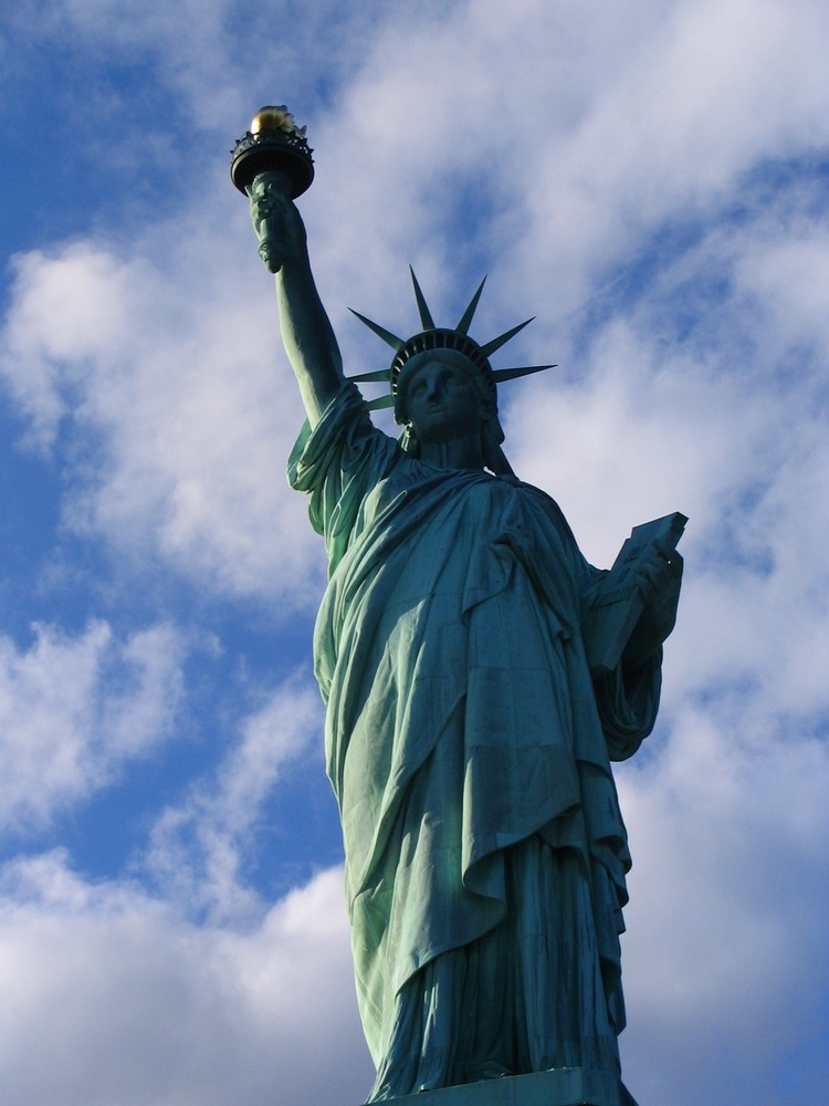 Liberty standing tall - symbolic features of Statue of Liberty, including torch, crown, robe, tablet of law.