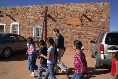 Education Specialist providing a school group a tour of the Hubbell Trading Post.