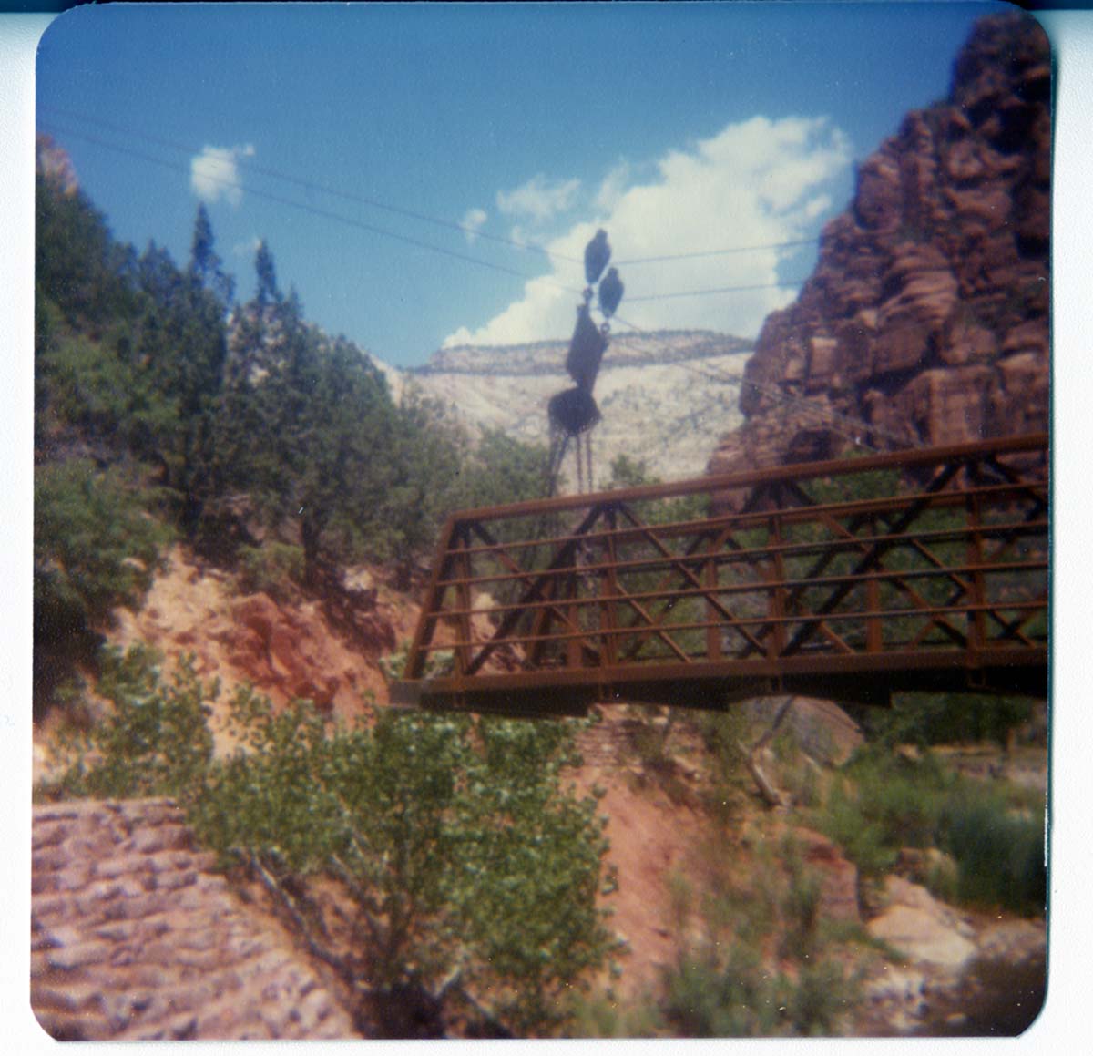 The new Grotto footbridge moving by pulley system towards the stone abutment across the Virgin River.