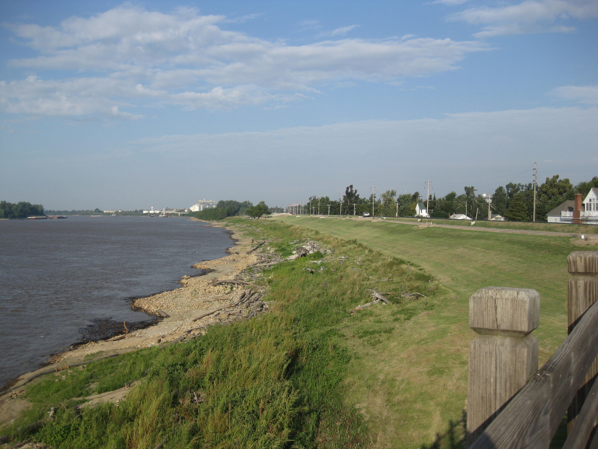 A wooden fence next to a large body of water.