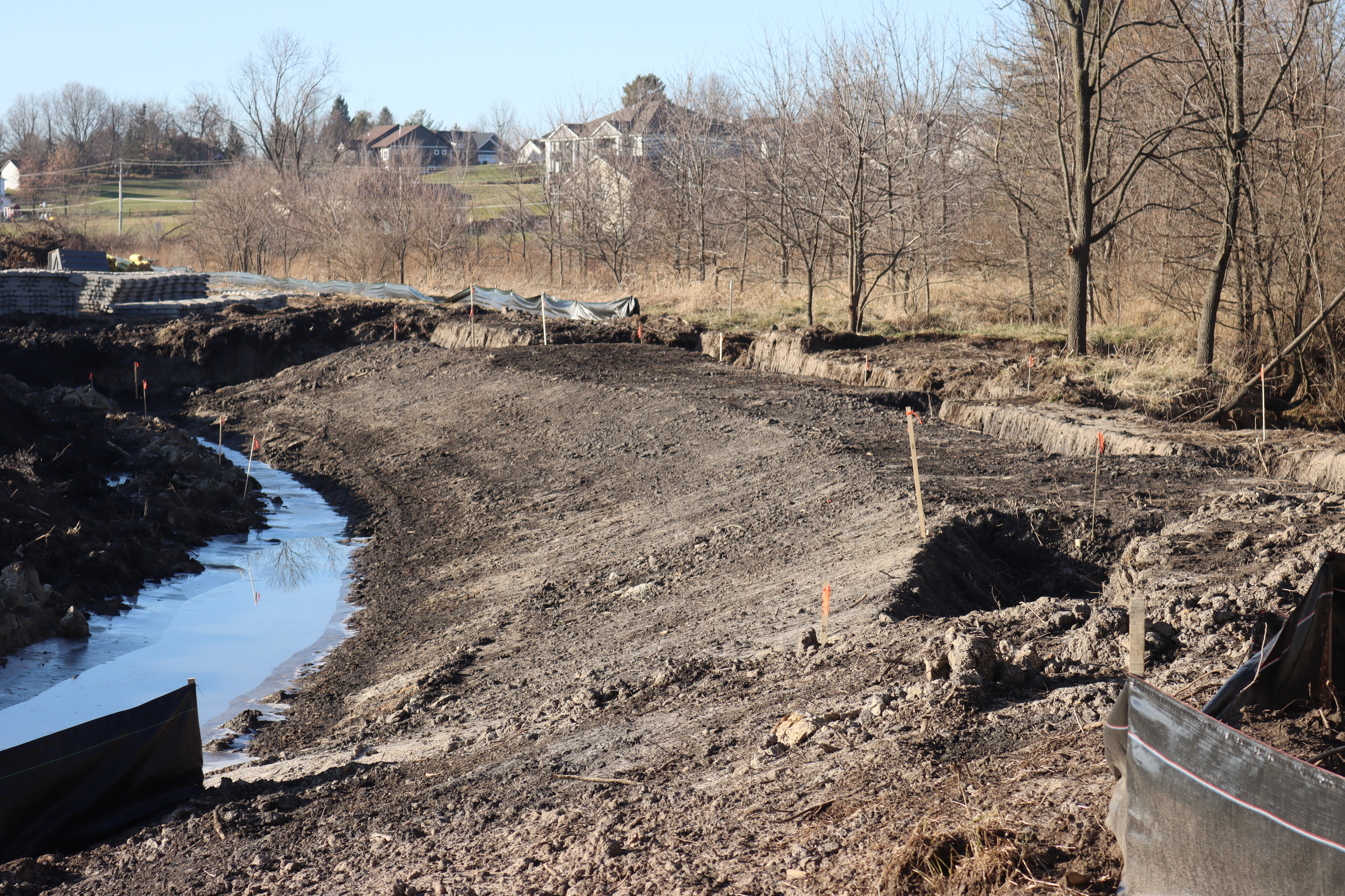 Sculpted dirt bank curves from the center foreground to the left background. The bank is flat at the top and drops off to the left.