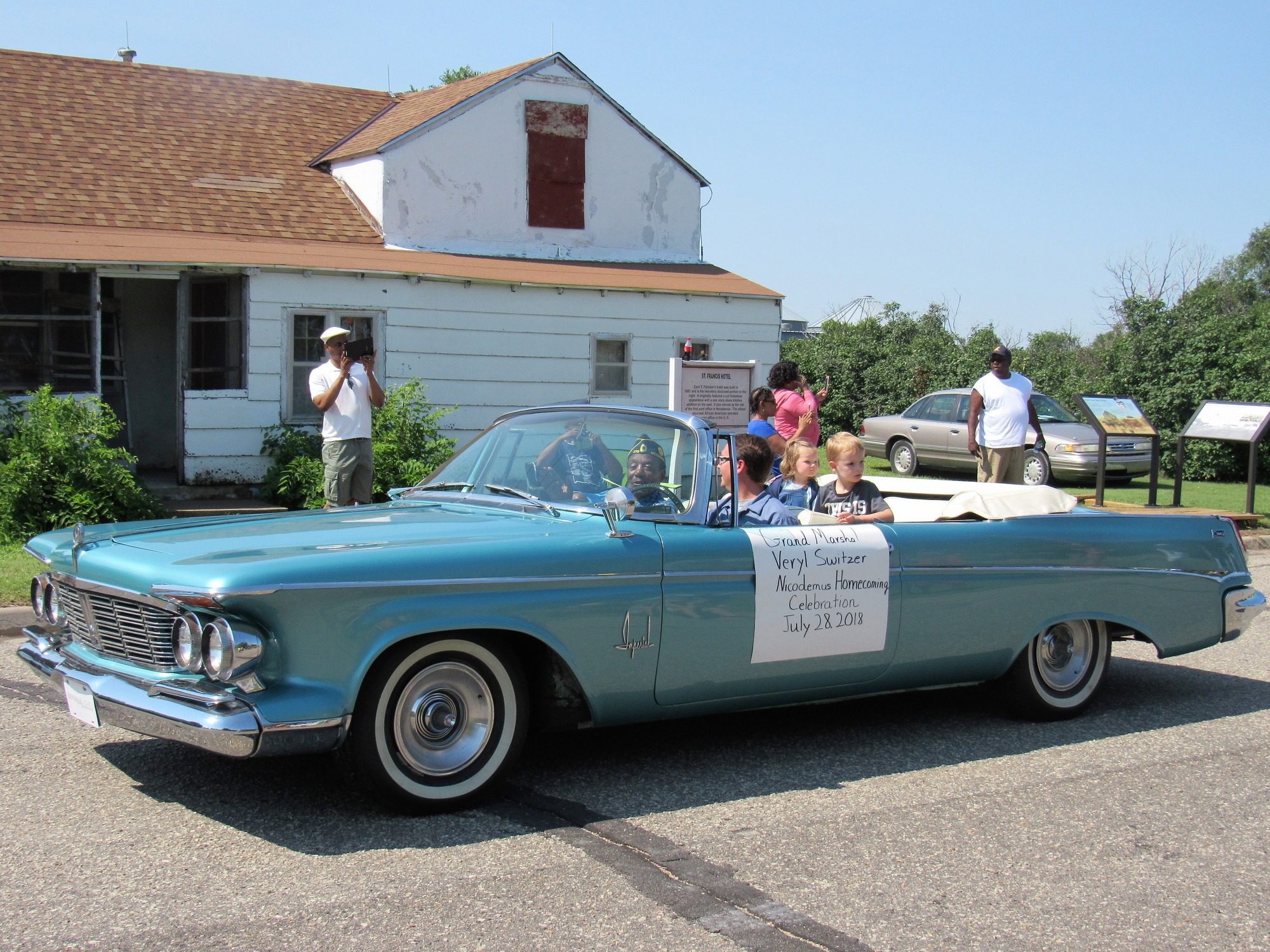vintage car being driven in a parade