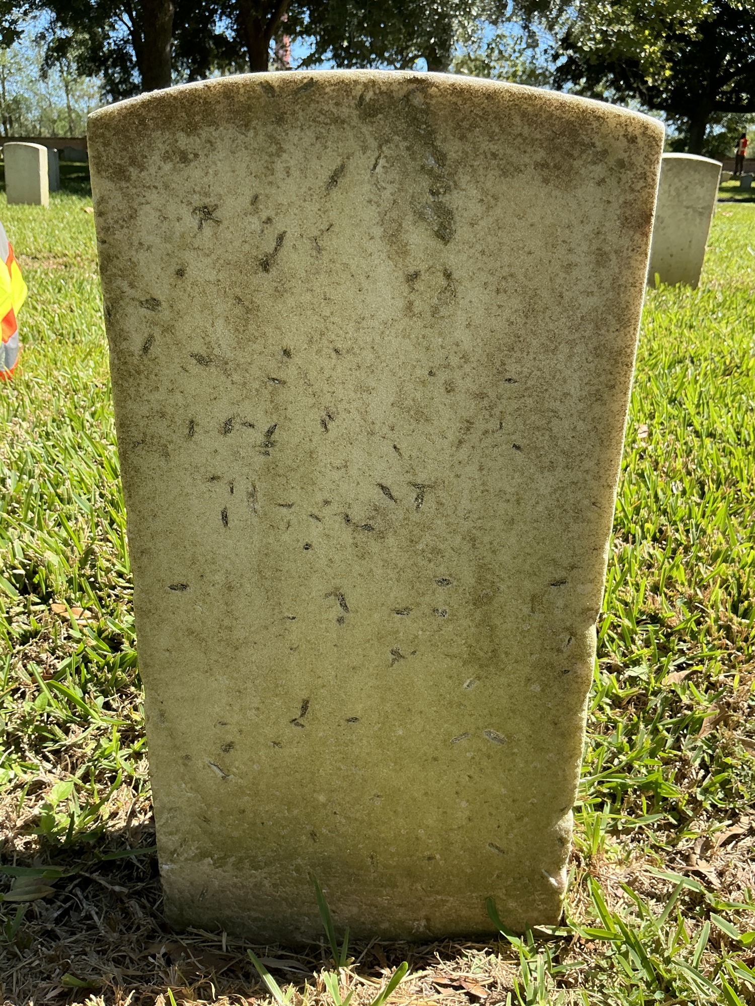 Back of historic upright marble headstone with recessed shield face.