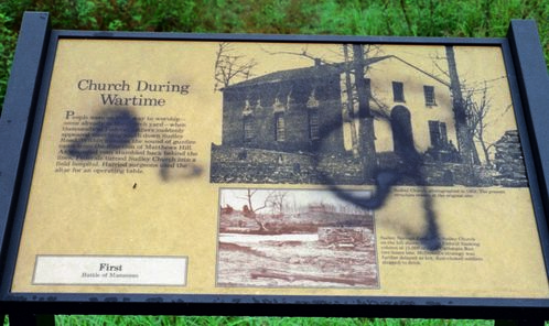 Sudley Methodist Church site signs at north entrance to park
