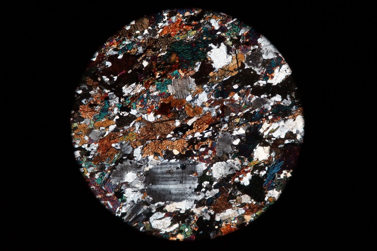 Circular microscopic image of rock structure.