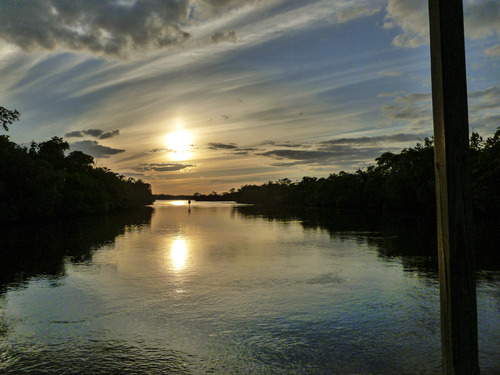 Sunset over a waterway lined with trees