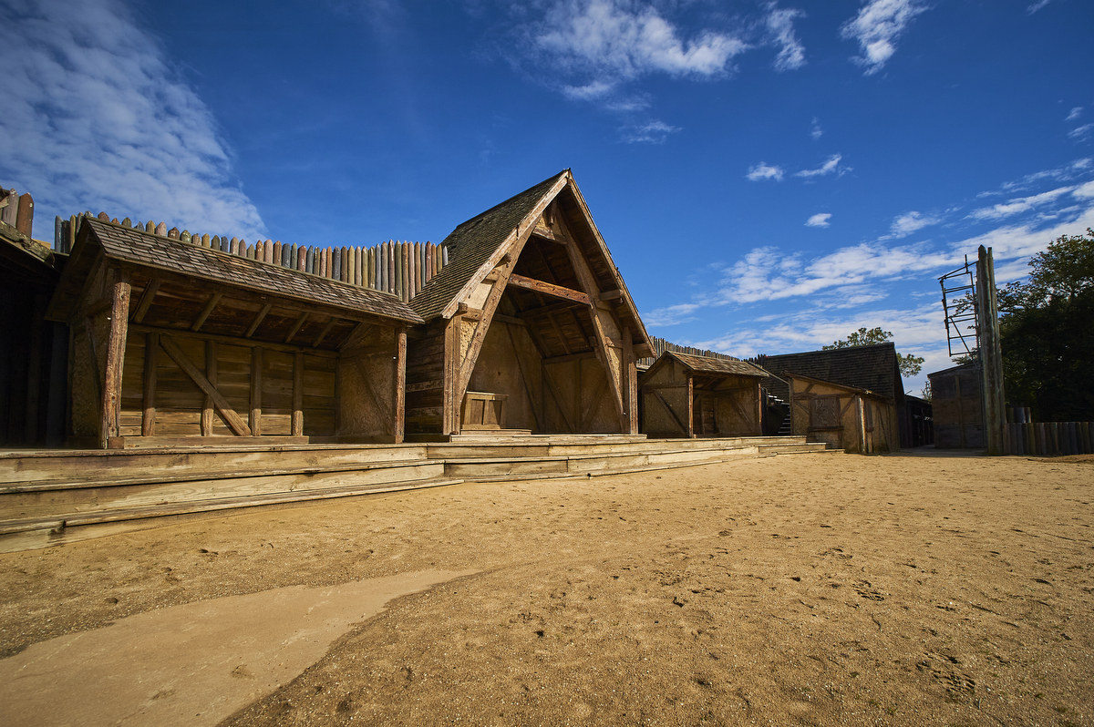Stage set of wooden buildings with a sandy floor