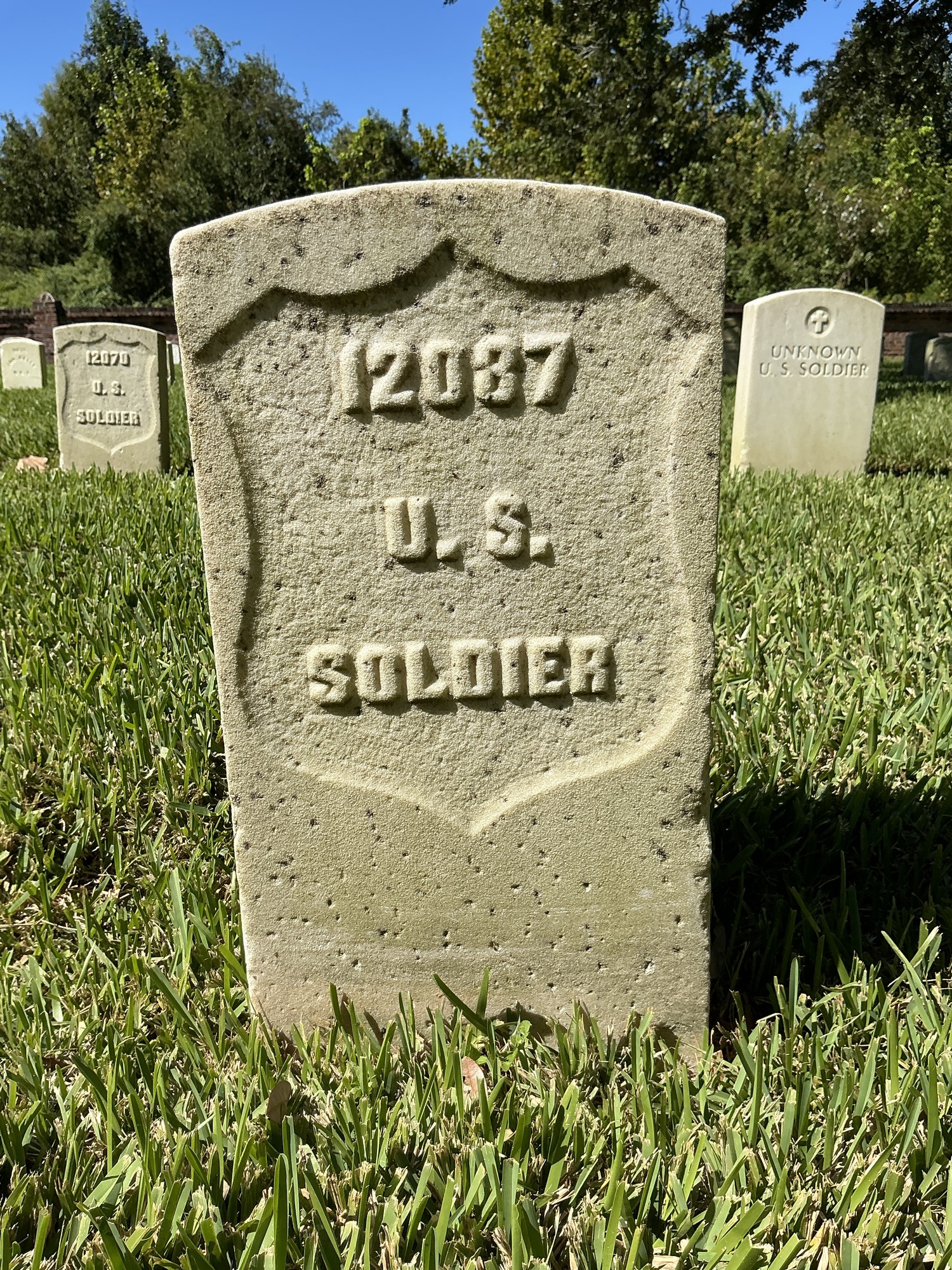 Front of historic upright marble headstone with recessed shield face.
