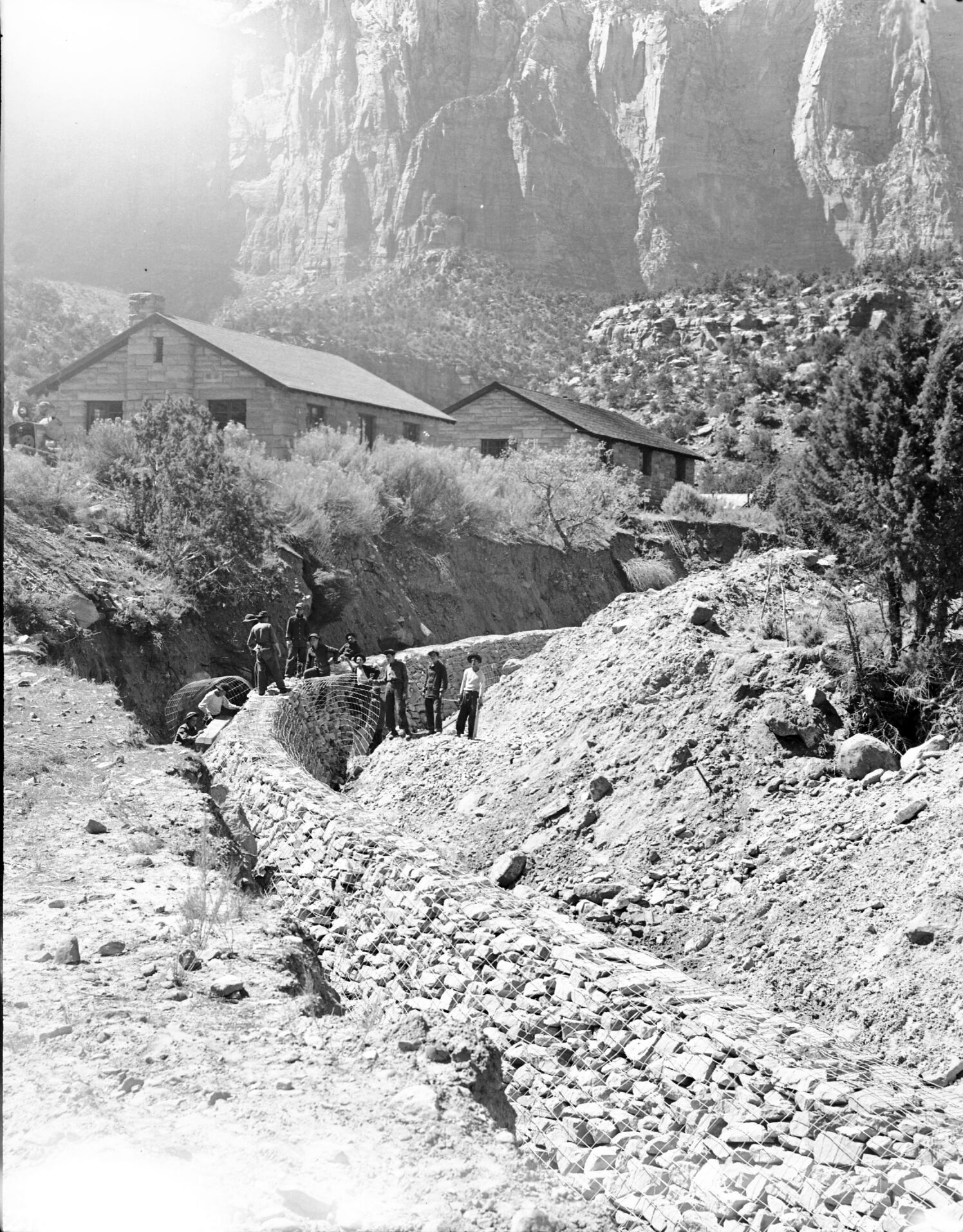 Civilian Conservation Corps (CCC) workers constructing stone retaining wall on Oak Creek near the utility area.