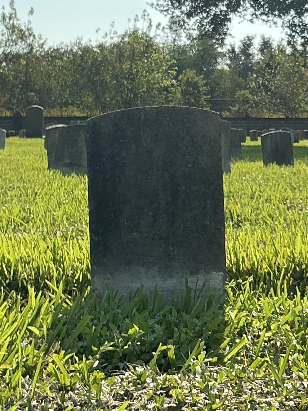 Back of historic upright marble headstone with recessed shield face.