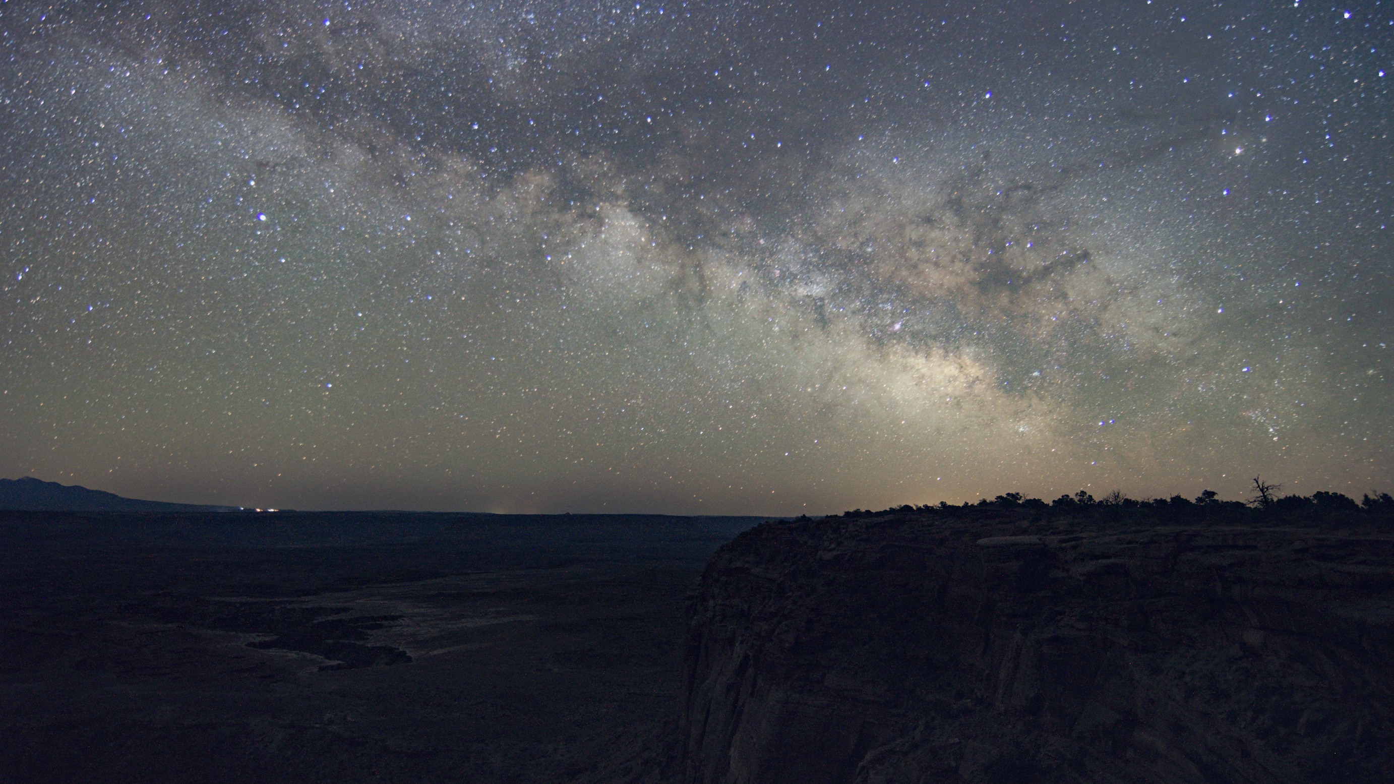 The Milky Way spans across the night sky. Stars surround the Milky Way. 