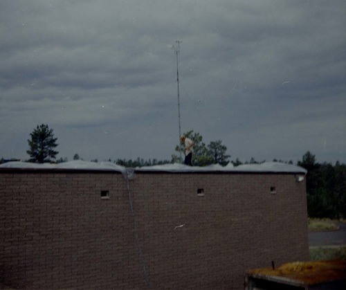 Man spraying foam sealant during reroofing project, plastic sheeting along edges of roof. Bryce Canyon National Park.